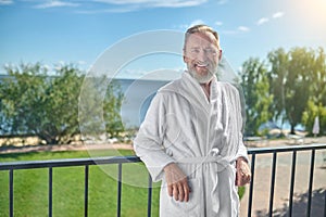 Happy vacationer posing for the camera on the balcony