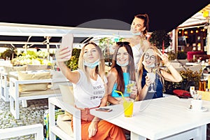 Happy vaccinated young girl friends taking selfie at cocktail party at trendy pub restaurant