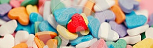 Happy Valentine day. Many small candies colorful hearts. One red heart in centre. Concept of love and February holiday. Web banner