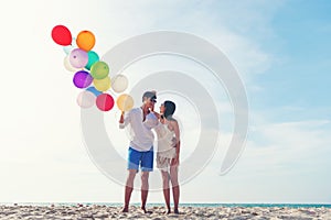 Happy Valentine day. Smiling couple hand holding balloon on the sand beach. Lover romantic and relax Summer,
