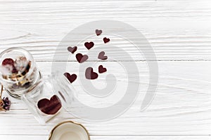 Happy valentine day. stylish hearts in glass jar and roses on w
