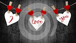 Happy Valentine`s Day background banner - White paper note hang on wooden clothes pegs with wooden hearts on a string isolated on