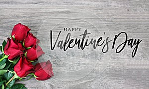 Happy Valentine`s Day Calligraphy Font Text with Beautiful Red Rose Flowers in Corner Over Light Wood Background