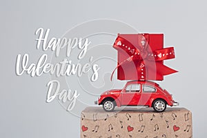 Happy Valentine`s Day card. Red retro toy car with romantec gift