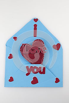 Happy valentine`s day concept. Flat lay top view photo of blue open envelope with paper card in shape of heart