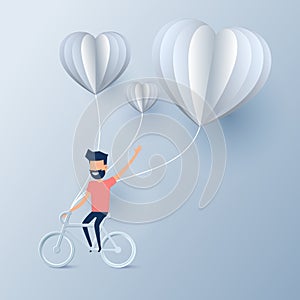 Happy valentine`s day concept of love. Man riding bicycle with heart shape hot air balloons. Paper art design.