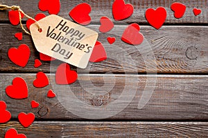 Happy Valentine`s Day design. Red hearts frame with lable on dark wooden background top-down copy space
