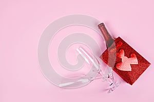 Happy Valentine's Day flatlay. Top view bottle of rose champagne in gift box, hearts, glasses on soft pink background