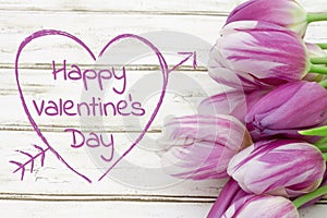 Happy Valentine`s Day greeting with tulips on weathered wood