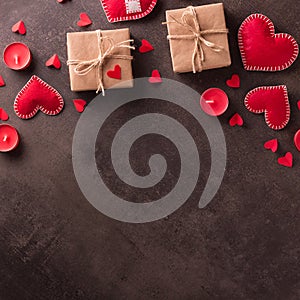 Happy Valentine`s Day. Handmade jewelry red hearts, gifts in craft paper and candles on dark background