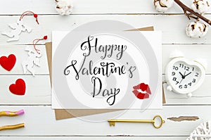 Happy Valentine`s Day lettering on vintage paper sheet with golden key, heart shaped alarm clock,. red hearts on white