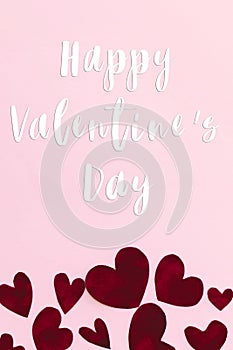 Happy Valentine`s Day text on stylish red hearts on pink background, flat lay. Happy Valentines Day greeting card. Be my Valentin