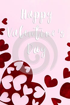 Happy Valentine`s Day text on stylish red hearts on pink background, flat lay. Happy Valentines Day greeting card. Be my Valentin