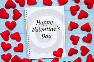 HAPPY VALENTINE`S DAY word on notebook with pink heart shape decoration on blue wooden table background. Wedding, Romantic and