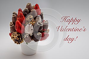 Happy Valentine`s greeting card with red lettering; A bundle of edible flowers, arrangement of strawberries covered with chocolat