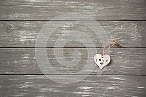 Happy Valentines Day background. Decorative white wooden heart on grey rustic. Valentine`s concept.