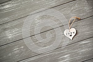 Happy Valentines Day background. Decorative white wooden heart on grey rustic. Valentine`s concept.
