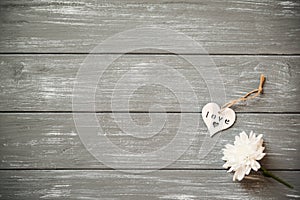 Happy Valentines Day background. Decorative white wooden heart on grey rustic, whith flowers, Valentine`s concept.