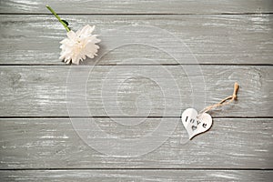 Happy Valentines Day background. Decorative white wooden heart on grey rustic, whith flowers, Valentine`s concept.