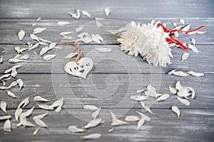 Happy Valentines Day background. Decorative white wooden heart on grey rustic, whith flowers, Valentine`s concept.