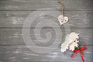Happy Valentines Day background. Decorative white wooden heart on grey rustic, whith flowers, Valentine`s concept.