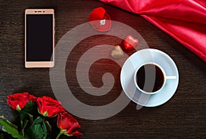 Happy Valentines Day background with wedding ring, rose flowers, smartphone, cup of coffee and chocolate candy