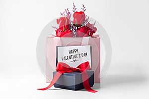 Happy valentines day with card, black gift box and rose bouquet in paper bag on white background