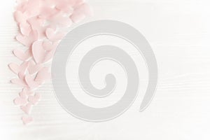 Happy valentines day. Cute pink pastel hearts on white wooden background with space for text.  Pink paper heart cutouts border on