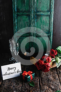 Happy valentines day greeting card, present, red roses and champagne bottle