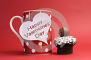 Happy Valentines Day message on red polka dot mug with chocolate cupcake