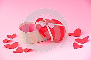 Happy valentines day, opened heart shape gift box with ribbon and small paper hearts, on pink background