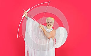 Happy Valentines day. Smiling bearded man in angel costume with bow and arrow. Male cupid in white angel wings with bow