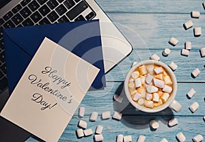 HAPPY VALENTINES DAY text Greeting card blue envelope with white cup of coffee and marshmallows laptop keyboard on