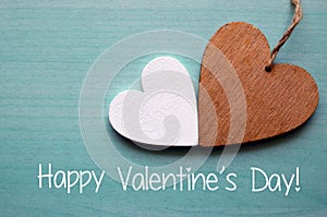 Happy Valentines Day.Two decorative wooden hearts on a blue wooden background.