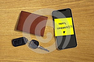 Happy Valentines romantic and sweet handwritten note on yellow posit stick to mobile phone next to car key and leather wallet in