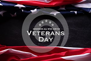 Happy Veterans Day. American flags with the text thank you veterans against a blackboard background. November 11