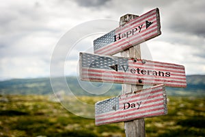 happy veterans day text on wooden american flag signpost outdoors