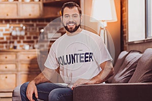 Happy volunteer beaming and sitting on the sofa