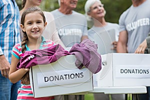 Happy volunteer family holding donation boxes