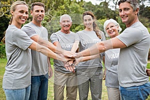 Happy volunteer family putting their hands together