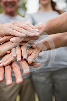 Happy volunteer family putting their hands together