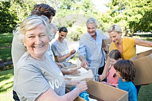 Happy volunteer family separating donations stuffs