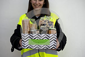 Happy volunteer holding a basket with donated food