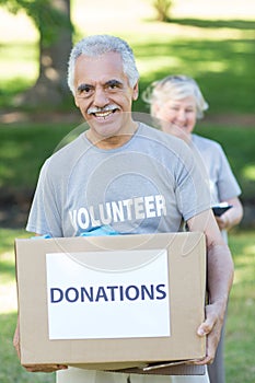 Happy volunteer senior holding donation box