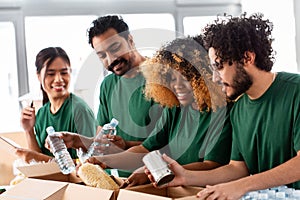 happy volunteers packing food in donation boxes