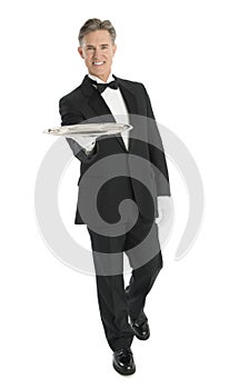 Happy Waiter With Serving Tray Walking Against White Background