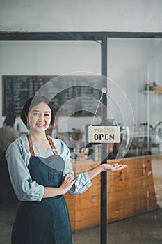happy waitress standing at restaurant entrance with open sign, Portrait of young business woman attend new customers