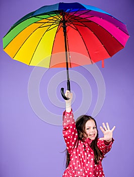 Happy walk under umbrella. Enjoy rain concept. Kid girl happy hold colorful rainbow umbrella. Rainy weather with proper