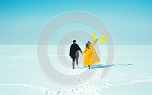 Happy walking couple. In love man and woman walking on the snowy ice. Winter vacation concept.