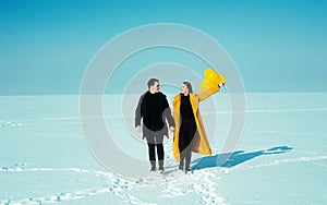 Happy walking couple. In love man and woman walking on the snowy ice. Winter vacation concept.